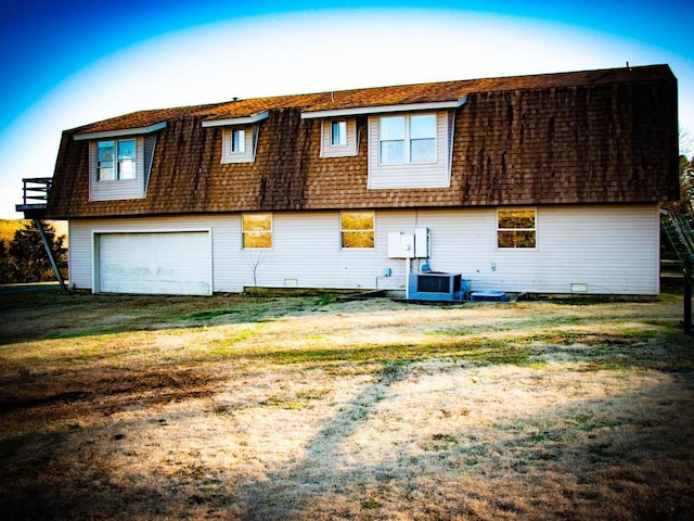 rear view of house with a garage and central AC