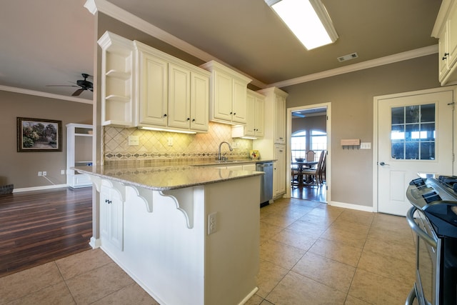 kitchen featuring a breakfast bar area, light stone counters, appliances with stainless steel finishes, and light tile patterned flooring