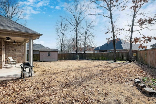 view of yard with a storage shed, ceiling fan, and a patio