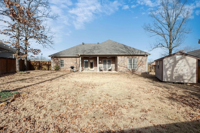 rear view of property featuring a storage unit