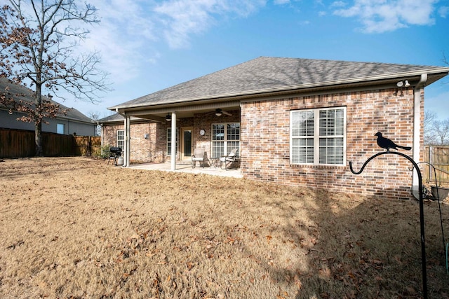 back of property featuring ceiling fan, a yard, and a patio