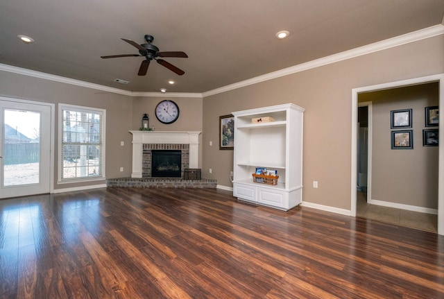 unfurnished living room featuring ceiling fan, dark wood-type flooring, ornamental molding, and a fireplace