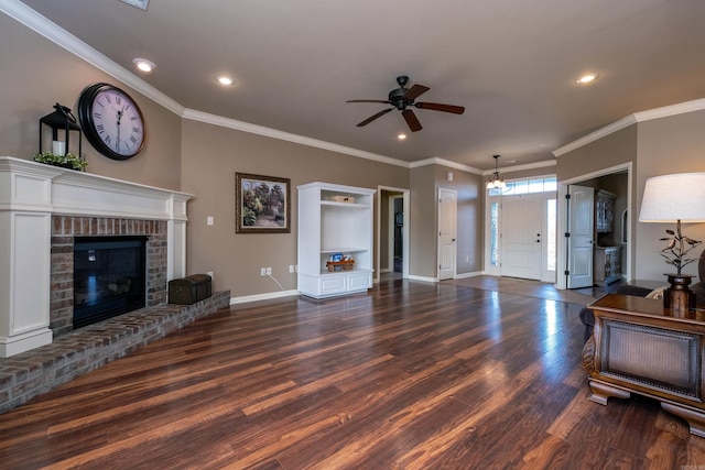 living room with ceiling fan, a brick fireplace, ornamental molding, and dark hardwood / wood-style flooring