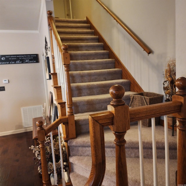 stairs featuring hardwood / wood-style flooring and ornamental molding