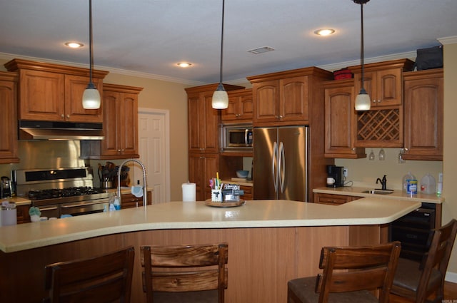 kitchen with decorative light fixtures, sink, a kitchen bar, and stainless steel appliances