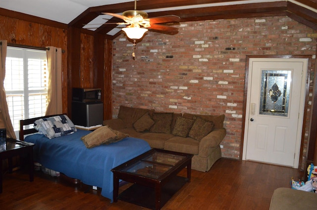 living room featuring brick wall, dark wood-type flooring, vaulted ceiling, and ceiling fan