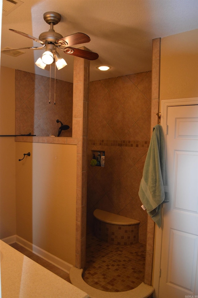 bathroom with ceiling fan and a tile shower