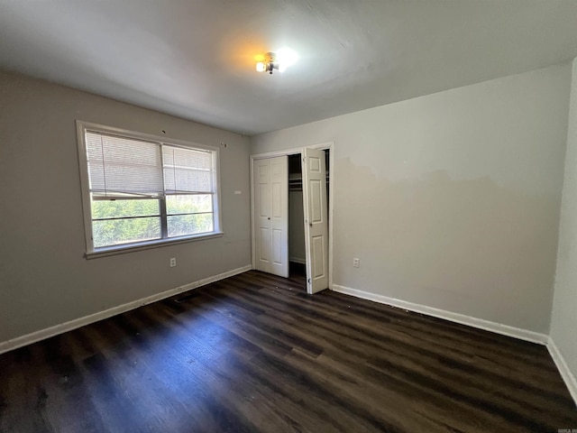 unfurnished bedroom featuring dark wood-type flooring and a closet