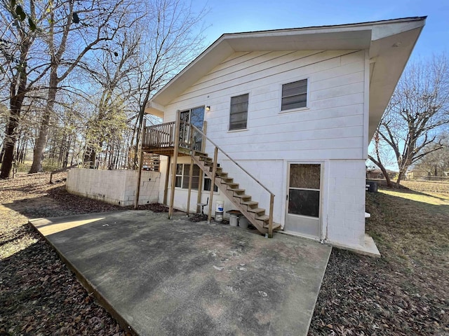 rear view of house featuring a patio area and a wooden deck