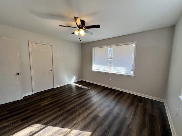 unfurnished room featuring dark wood-type flooring and ceiling fan