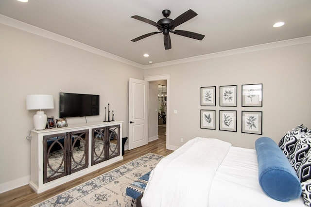 bedroom with ceiling fan, ornamental molding, and hardwood / wood-style flooring