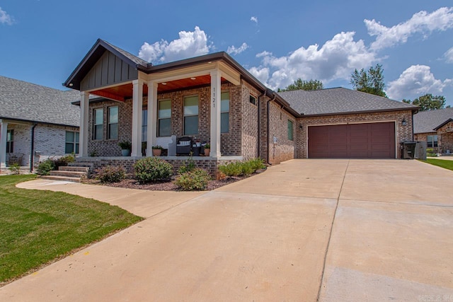 view of front of house featuring a garage, a front lawn, and covered porch