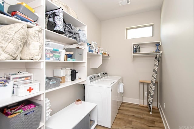 laundry area featuring wood-type flooring and washer and clothes dryer