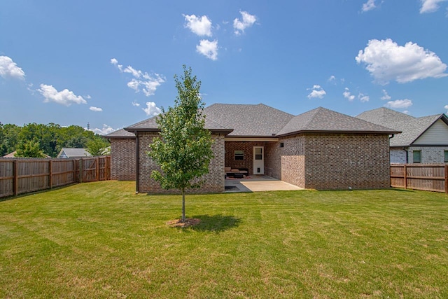 rear view of house with a lawn and a patio