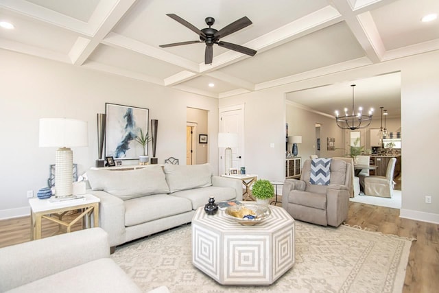 living room featuring ceiling fan with notable chandelier, coffered ceiling, light hardwood / wood-style flooring, and beamed ceiling