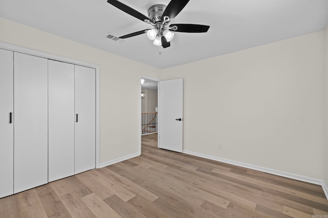 unfurnished bedroom featuring light wood-type flooring, ceiling fan, and a closet