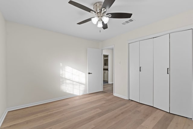 unfurnished bedroom featuring ceiling fan, light hardwood / wood-style floors, and a closet