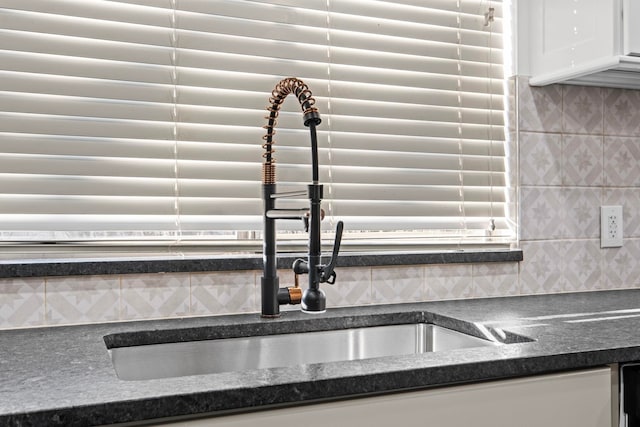 interior details with white cabinetry and decorative backsplash