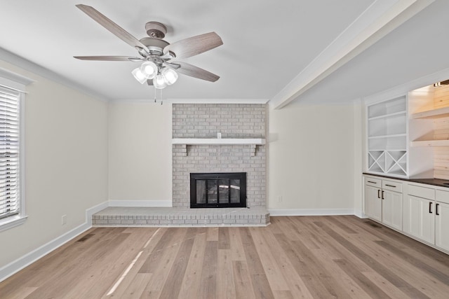 unfurnished living room featuring light hardwood / wood-style flooring, plenty of natural light, a fireplace, and crown molding