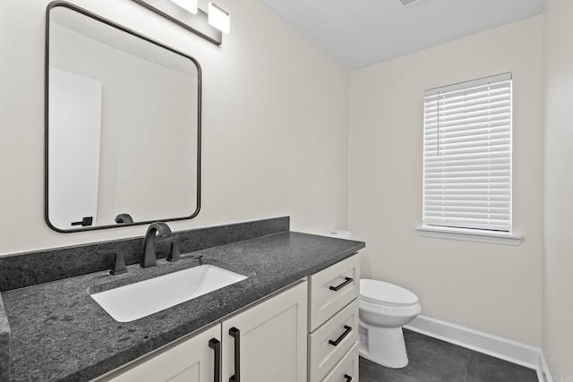 bathroom with toilet, tile patterned floors, and vanity