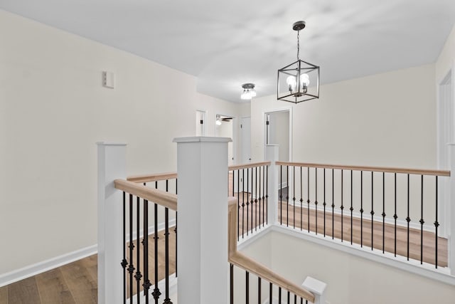 corridor featuring dark hardwood / wood-style floors and an inviting chandelier