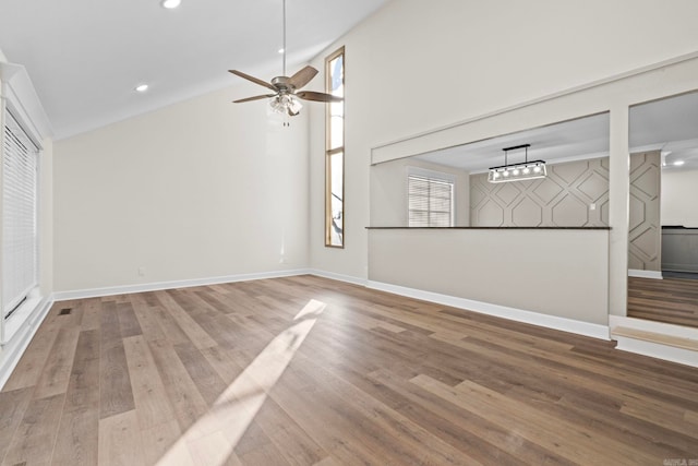 unfurnished living room with hardwood / wood-style flooring, high vaulted ceiling, and ceiling fan