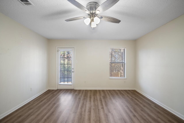 unfurnished room featuring ceiling fan, dark hardwood / wood-style floors, and a textured ceiling