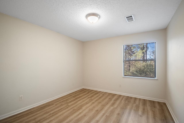 empty room featuring light hardwood / wood-style floors and a textured ceiling