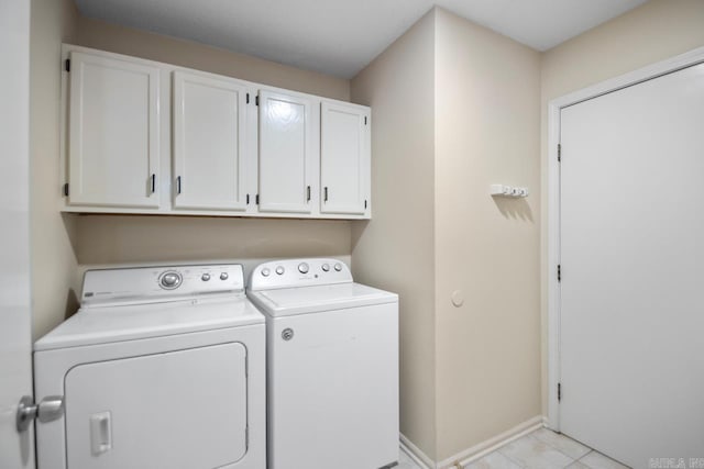 washroom with cabinets, washer and clothes dryer, and light tile patterned flooring