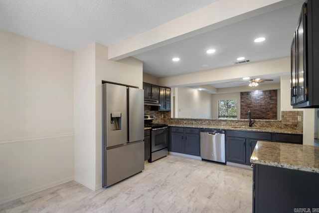 kitchen featuring stone countertops, ceiling fan, sink, backsplash, and stainless steel appliances