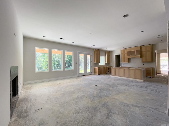 19100 Waterview Meadow Ln, Roland, AR 72135 - unfurnished living room featuring baseboards, unfinished concrete flooring, a fireplace, and french doors