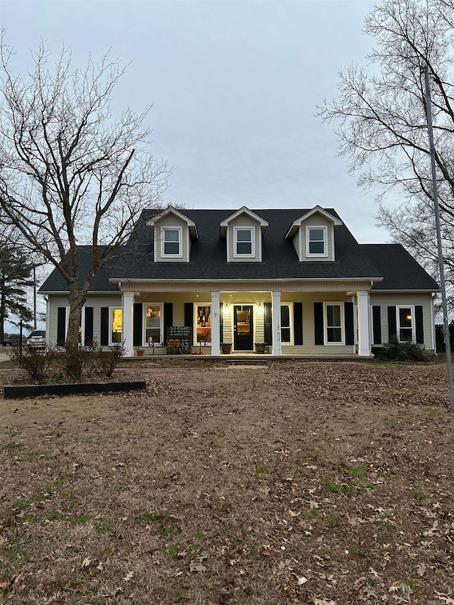 cape cod house featuring covered porch