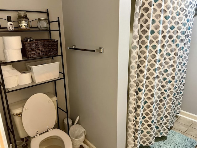 bathroom featuring a shower with curtain, toilet, and tile patterned flooring