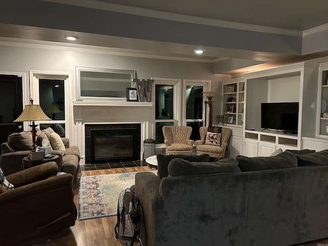 living room featuring built in shelves, ornamental molding, and dark hardwood / wood-style flooring