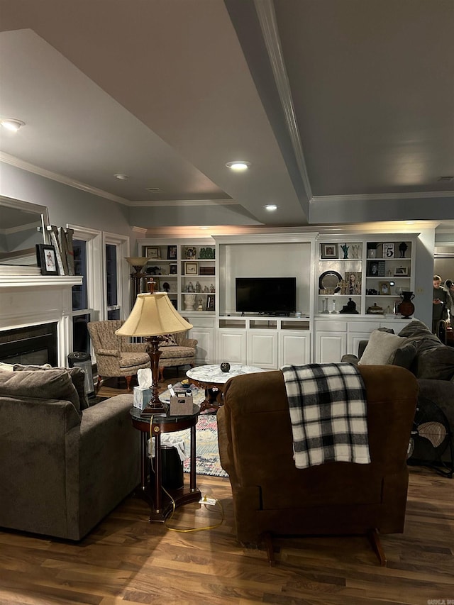 living room with built in shelves, hardwood / wood-style floors, and ornamental molding