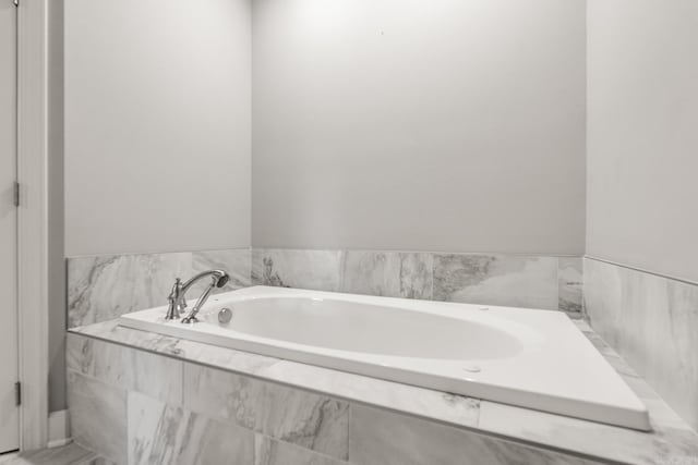 bathroom with a relaxing tiled tub