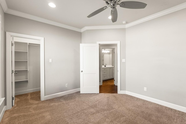 unfurnished bedroom with crown molding, a walk in closet, and dark colored carpet