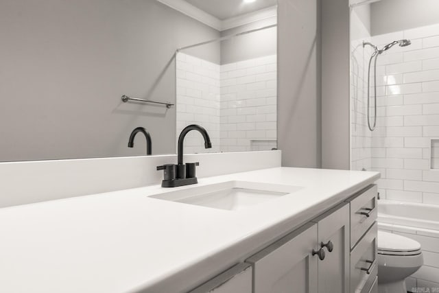 full bathroom with vanity, tiled shower / bath, crown molding, and toilet