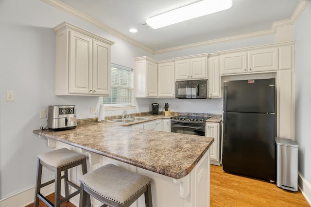 kitchen featuring sink, crown molding, black appliances, and kitchen peninsula