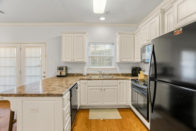 kitchen featuring sink, white cabinets, black appliances, and kitchen peninsula