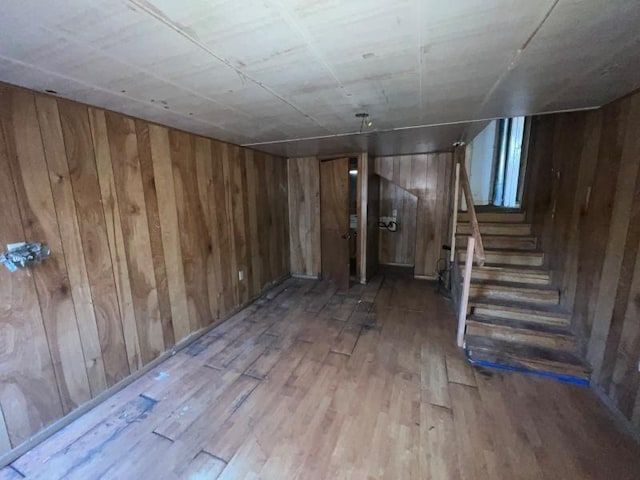 basement featuring wood walls and light wood-type flooring