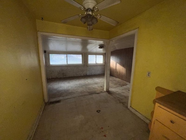 interior space featuring brick wall and ceiling fan