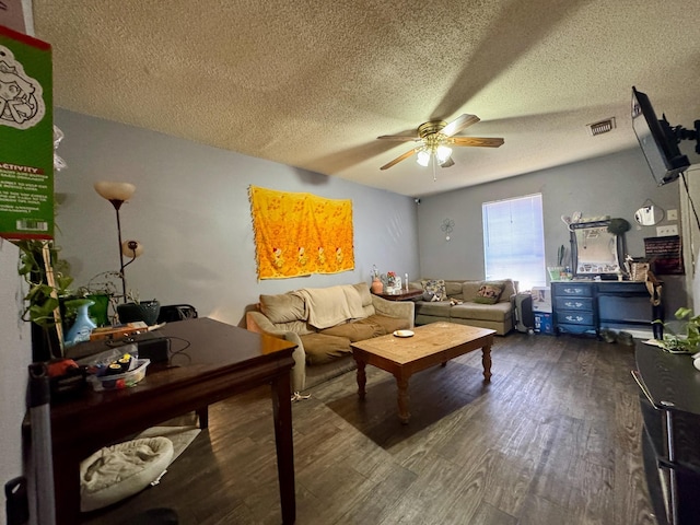 living room featuring ceiling fan, a textured ceiling, and dark hardwood / wood-style flooring