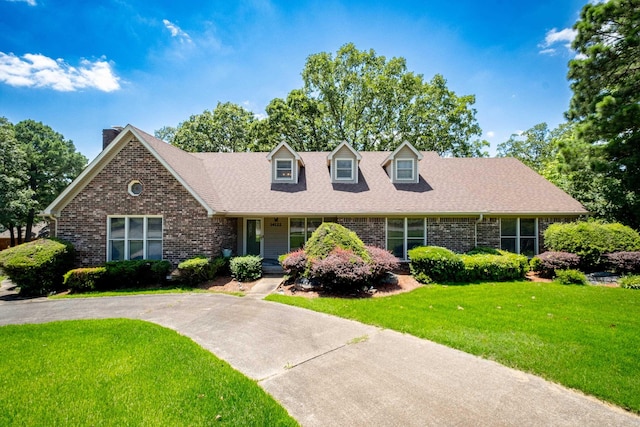 cape cod-style house with a front lawn