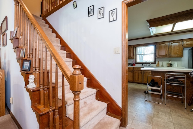 stairway with sink and crown molding