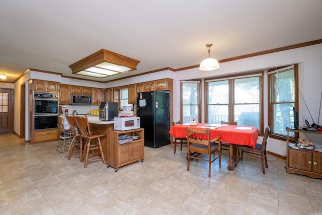 kitchen featuring black appliances, a center island, hanging light fixtures, a kitchen breakfast bar, and ornamental molding