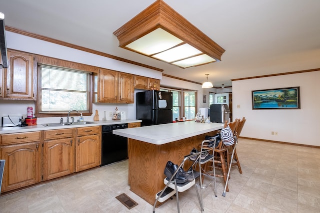 kitchen featuring black appliances, hanging light fixtures, sink, ornamental molding, and a breakfast bar area