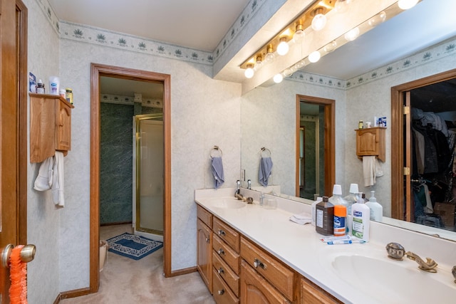 bathroom featuring a shower with shower door and vanity