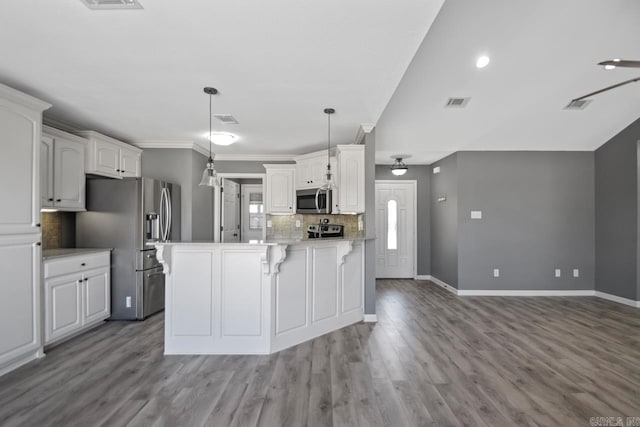 kitchen with white cabinets, pendant lighting, tasteful backsplash, and stainless steel appliances