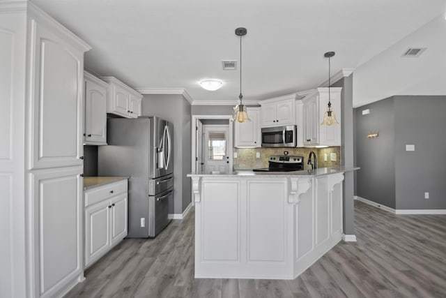 kitchen with white cabinetry, stainless steel appliances, sink, backsplash, and hanging light fixtures